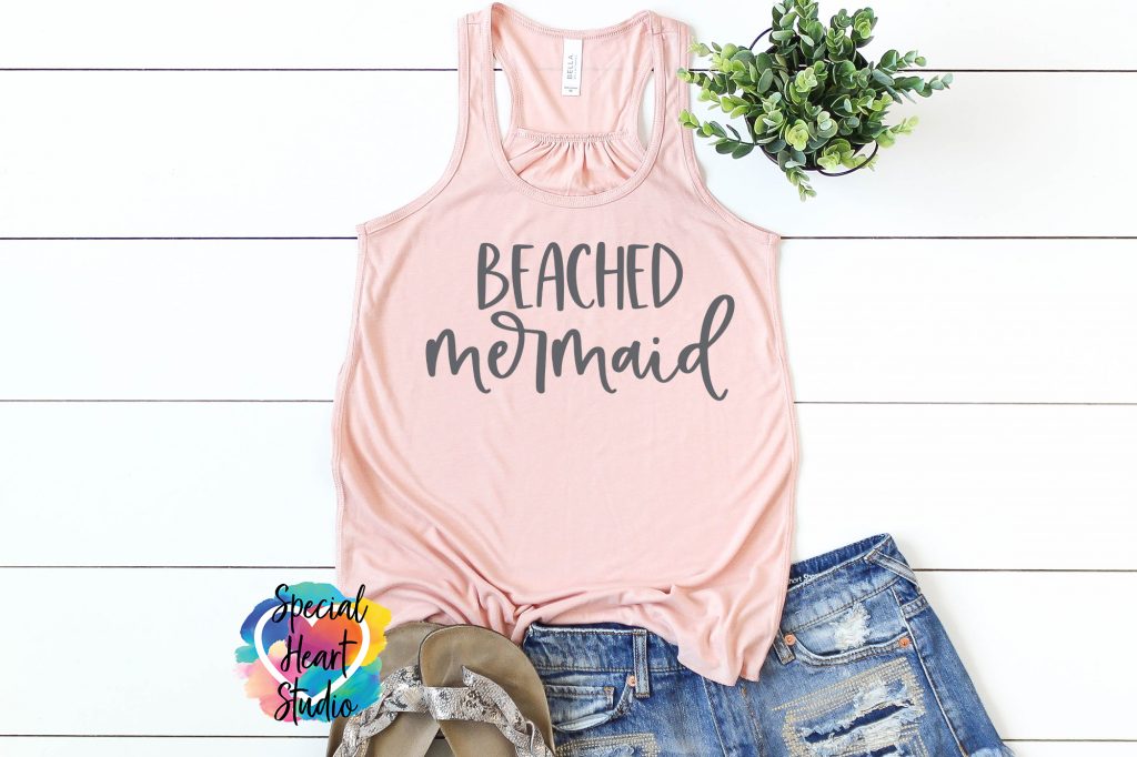 Peach tank top with Beached Mermaid in grey writing. Sandals and Jean shorts