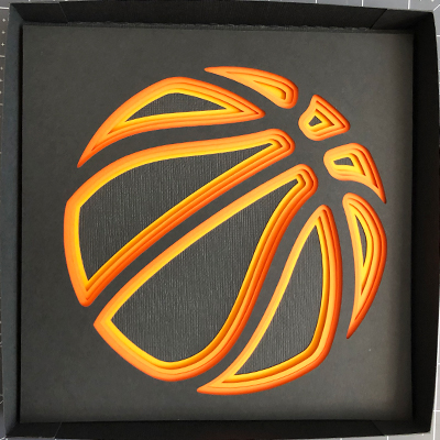 Partially assembled shadow box of layered basketball.