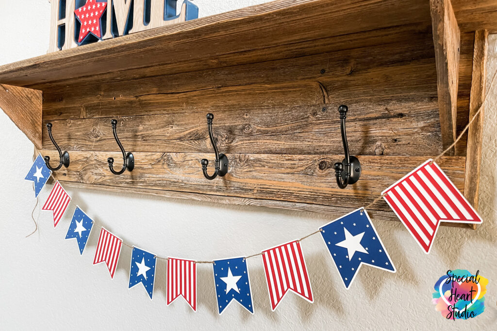 Wood shelf with hooks and hanging from it is a pennant banner.  Every other banner is red & white stripe or has a White background with blue and white stars.