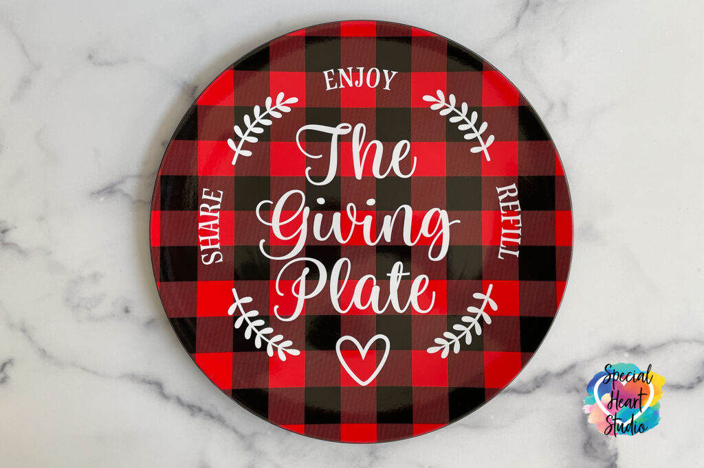 The Giving Plate in script font on a red and black buffalo plaid plate.